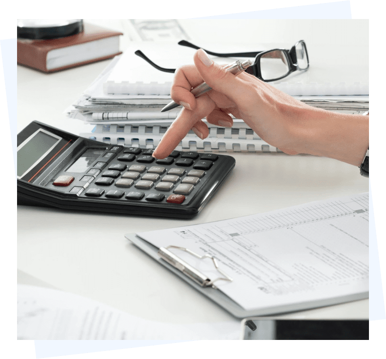 A person using a calculator on a desk.