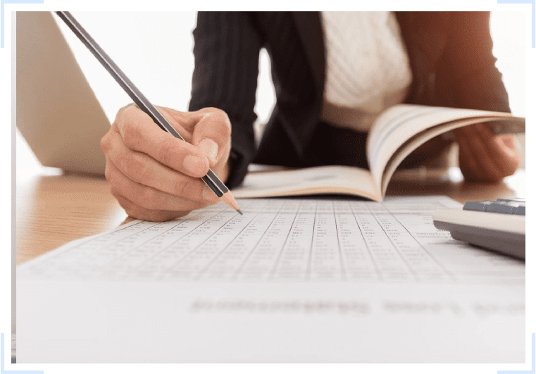 A woman is writing on a piece of paper with a pen.