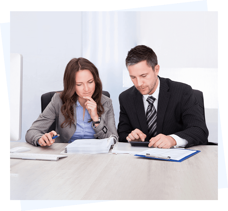 A businessman and woman working at a desk.