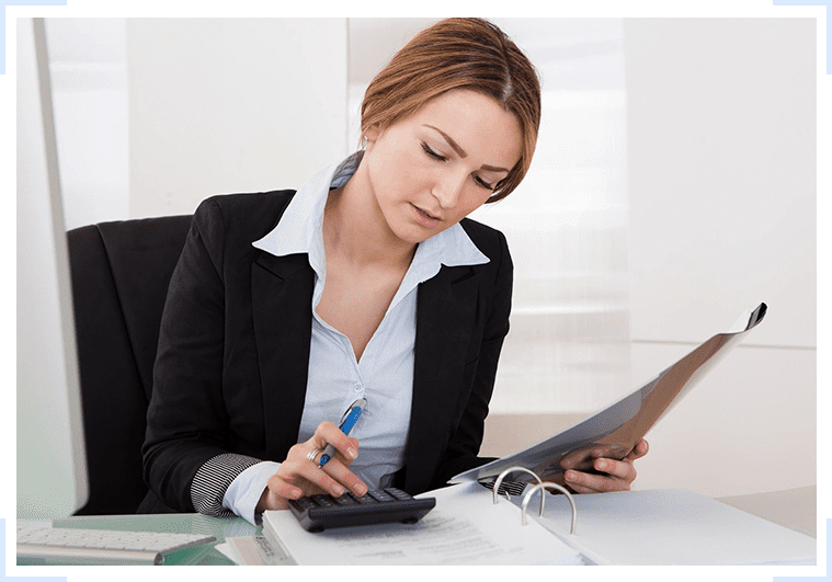 A woman in a business suit is working at her desk.